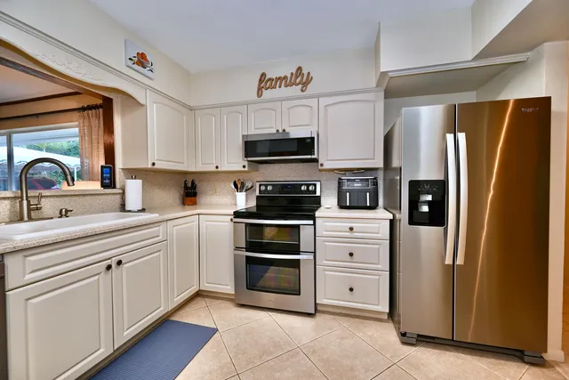 a kitchen with white cabinets and stainless steel appliances