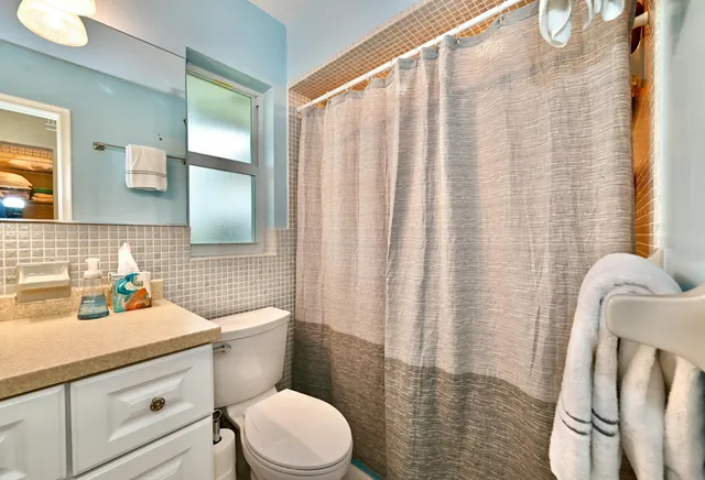a bathroom with a sink a toilet and shower curtain