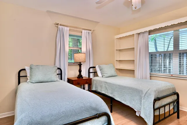 a bedroom with two beds and large window