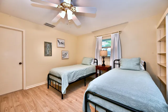 a bedroom with two beds and a chandelier
