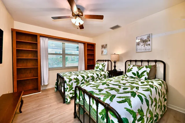 a bedroom with two beds and a chandelier