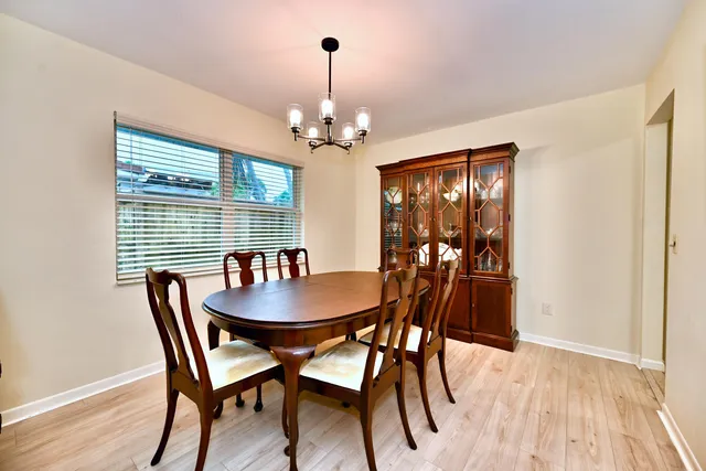 a dining room with furniture a chandelier and wooden floor