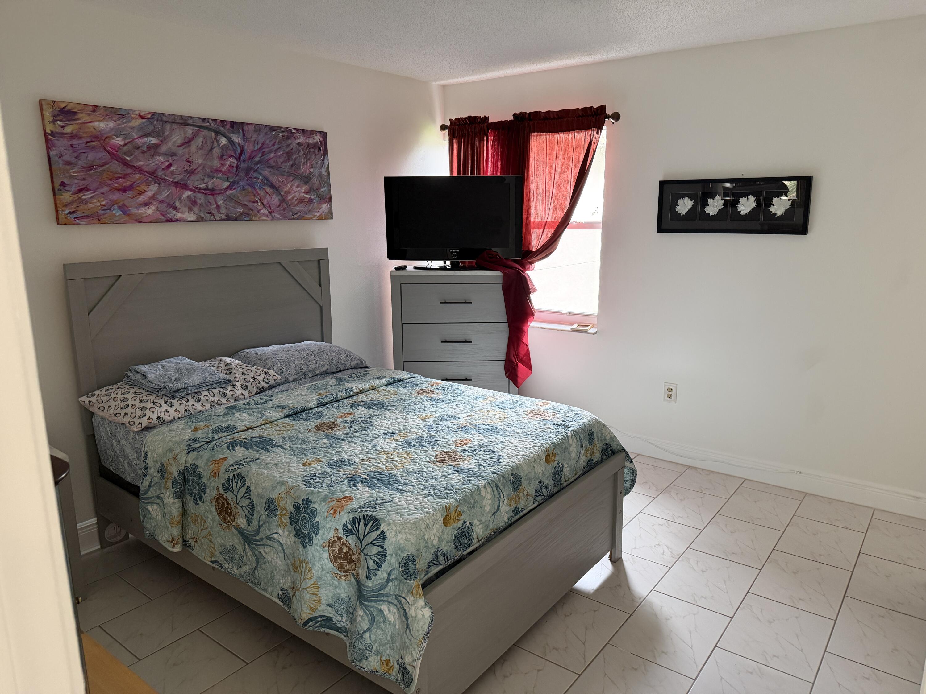 506 Davis Road, Unit 6 Palm Springs, FL 33461 - Photo 17 of 61 a bedroom with a bed and a flat screen tv