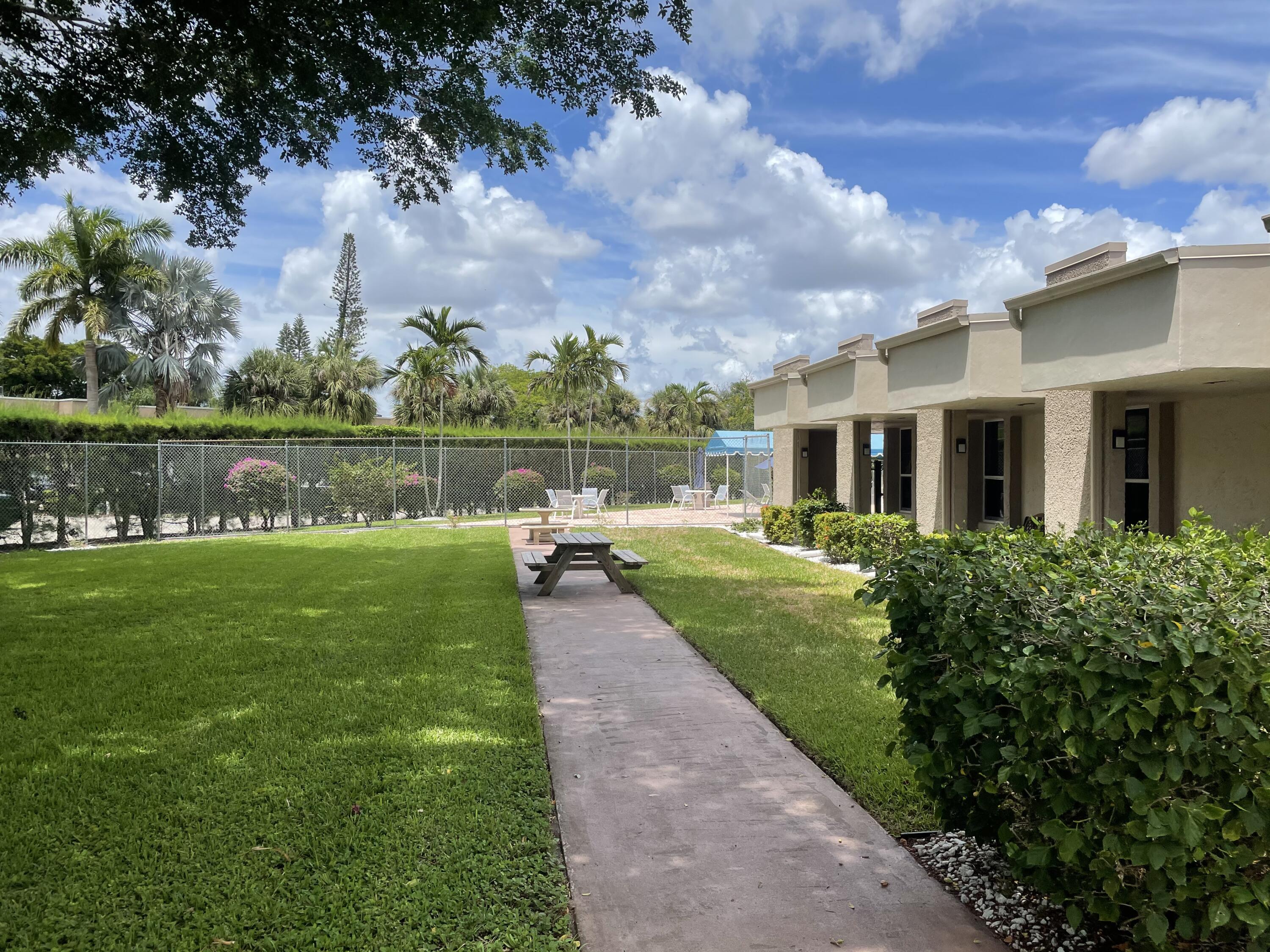506 Davis Road, Unit 6 Palm Springs, FL 33461 - Photo 32 of 61 a view of a lake with a big yard and large trees