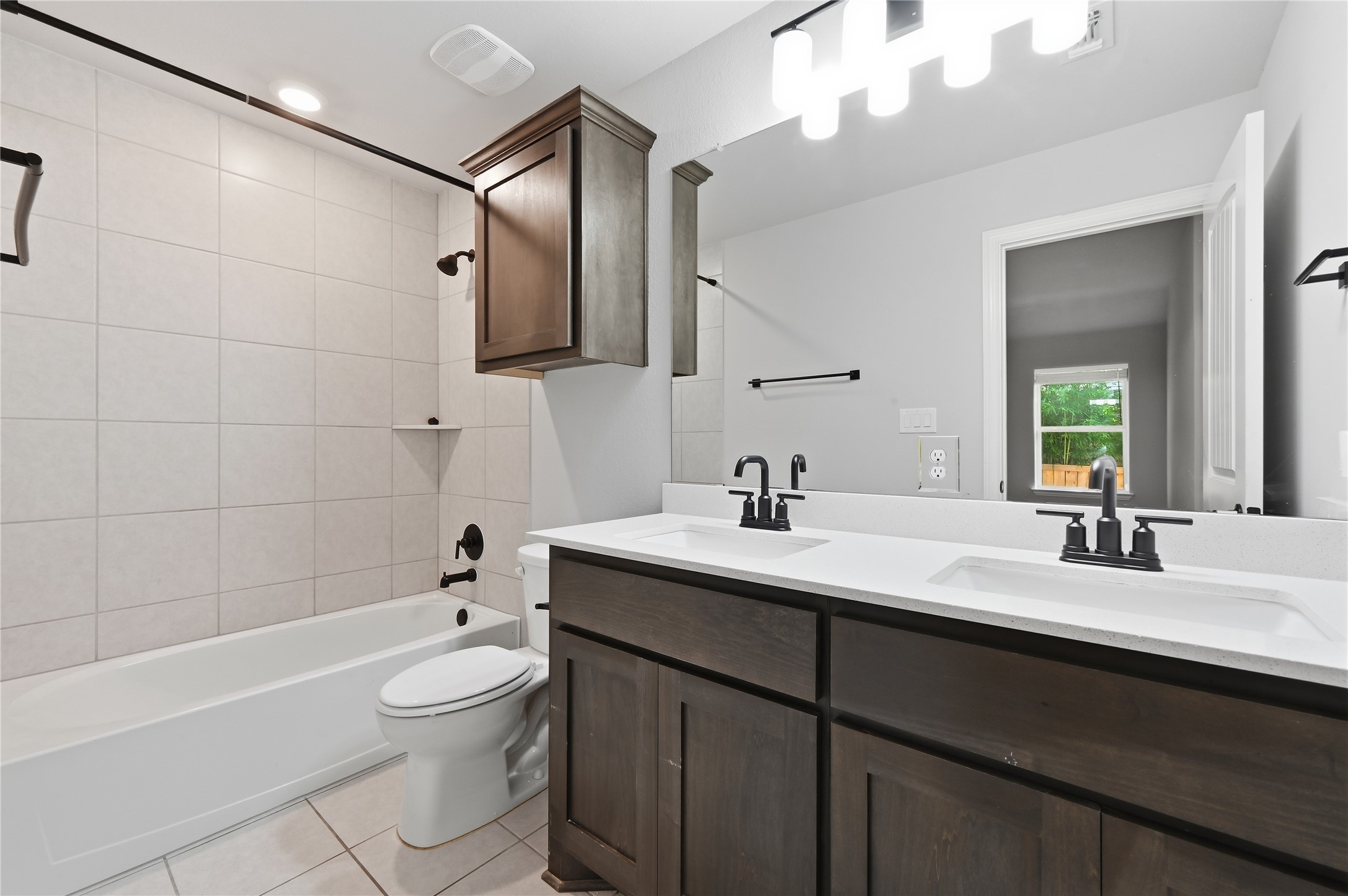 426 Cold Riv Run Kyle, TX 78640 - Photo 24 of 34 Double vanity sinks and dark wood cabinetry provide functionality and style to this well-appointed bathroom.