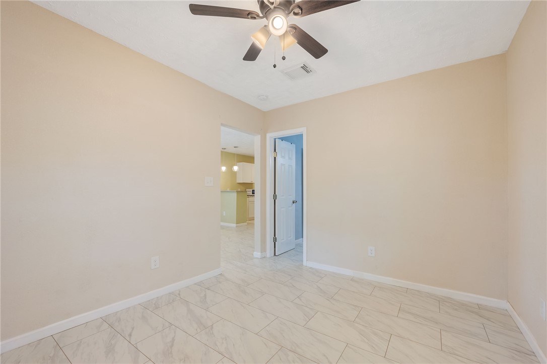 401 East 3rd Street Hearne, TX 77859 - Photo 6 of 24 an empty room with chandelier fan and windows