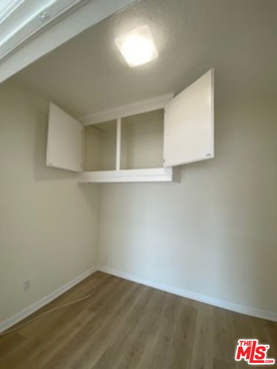 814 South Hobart Boulevard, Unit 410 Los Angeles, CA 90005 - Photo 18 of 22 a view of an empty room with wooden floor and a window