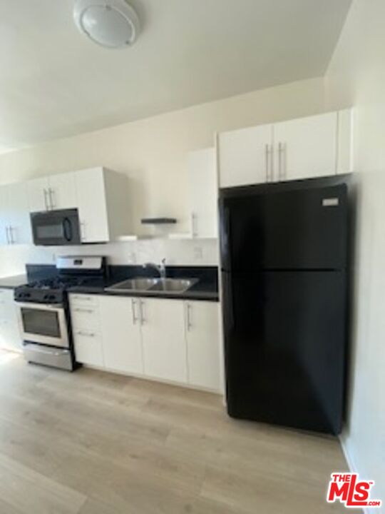 814 South Hobart Boulevard, Unit 410 Los Angeles, CA 90005 - Photo 5 of 22 a kitchen with a refrigerator and a stove