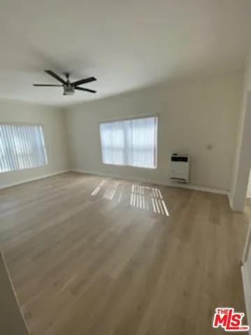 an empty room with windows and cabinet