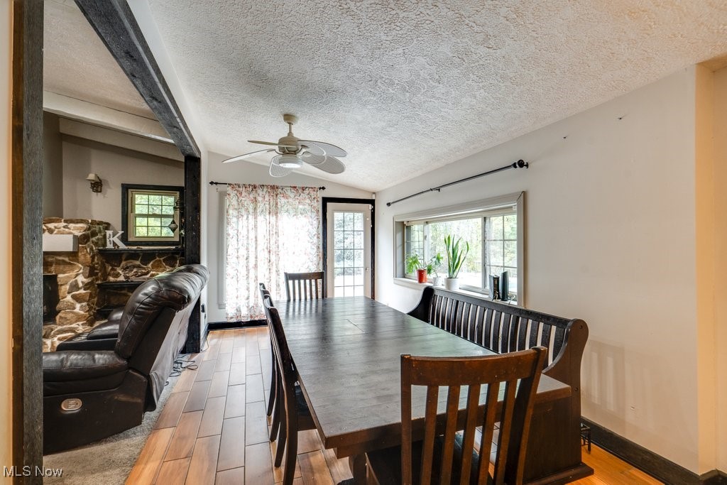 4100 Jade Road Northwest Carrollton, OH 44615 - Photo 18 of 37 Dining room featuring a textured ceiling, vaulted ceiling, wood-type flooring, and ceiling fan