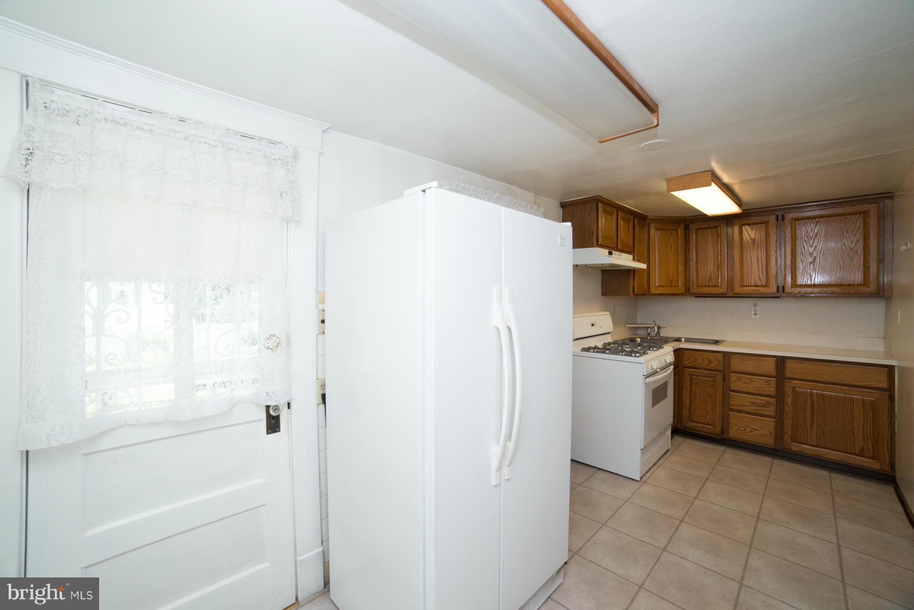 5415 Highview Road Baltimore, MD 21227 - Photo 9 of 25 a kitchen with granite countertop a refrigerator a sink and dishwasher