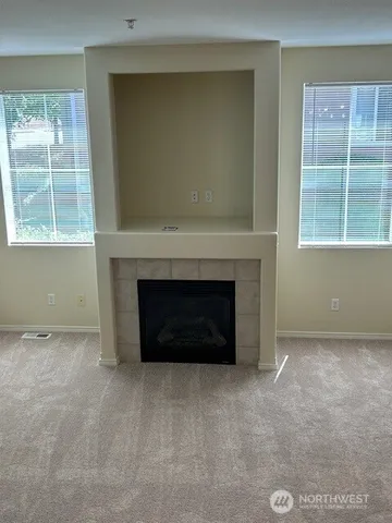 an empty room with a fireplace and windows