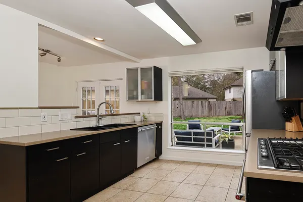 a kitchen with stainless steel appliances a sink stove and cabinets