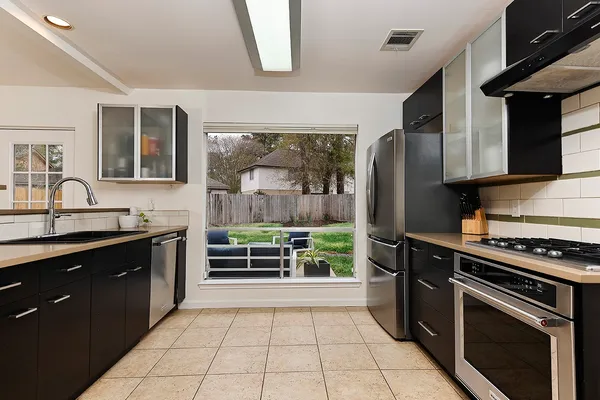 a kitchen with stainless steel appliances a stove a sink and a refrigerator