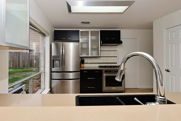 a kitchen with a refrigerator a oven and a sink