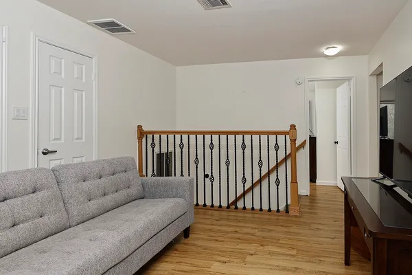 a living room with furniture ceiling fan and a wooden floor