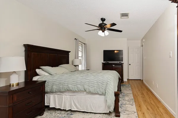a bedroom with a bed and a tv on the dresser