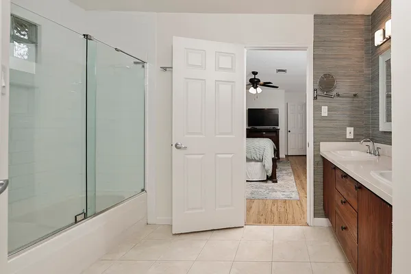 a bathroom with a tub shower and sink