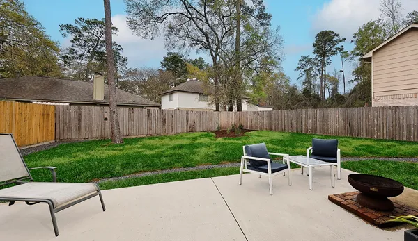 a view of a chair and table in backyard of the house