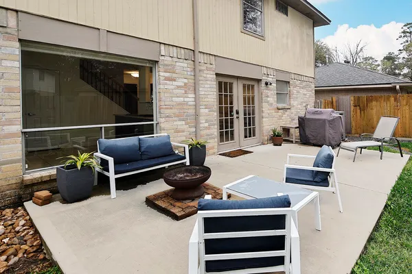 a view of a patio with couches chairs and wooden floor