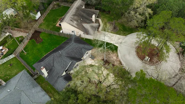 an aerial view of a house with a yard and trees