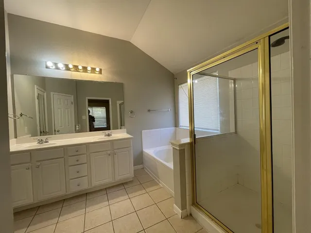a spacious bathroom with a mirror a sink and a shower
