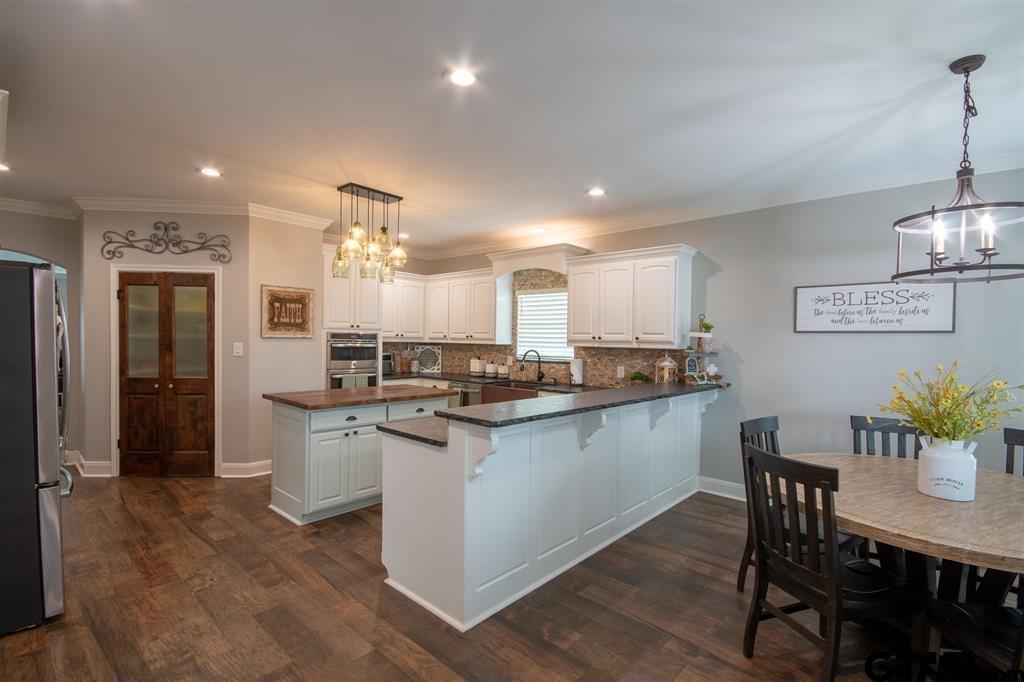 501 Maji Road Whitehouse, TX 75791 - Photo 9 of 12 a kitchen with a dining table chairs stainless steel appliances and cabinets