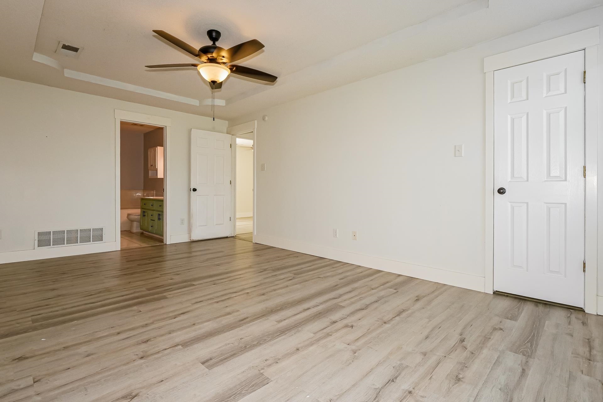 188 David Reed Drive Munford, TN 38058 - Photo 10 of 20 Spacious room featuring wood-finish flooring, a ceiling fan with integrated lighting, and a tray ceiling detail