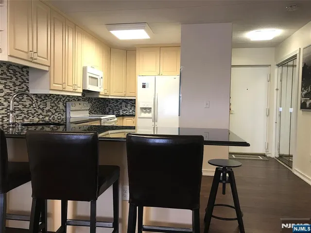 a kitchen with a table chairs refrigerator and cabinets