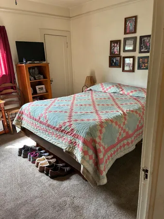 a bed sitting in a bedroom and tv