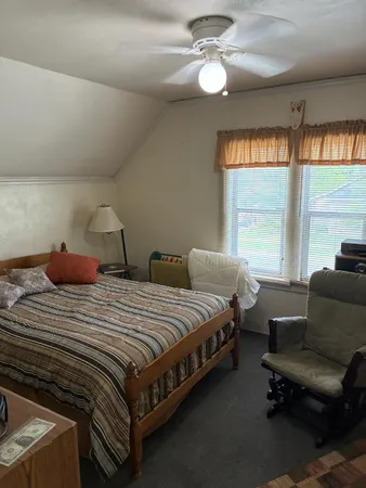 a bedroom with bed and a large window
