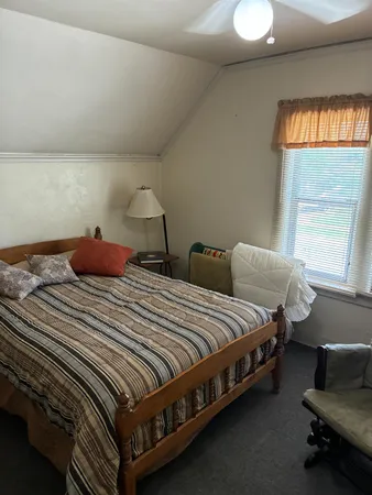 a bedroom with bed and a window