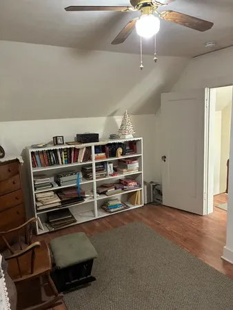 a view of an empty room with furniture and a window