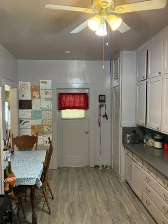 a kitchen with stainless steel appliances granite countertop a stove a refrigerator and a dining table with wooden floor