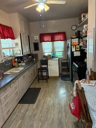 a kitchen with stainless steel appliances granite countertop a sink dishwasher and a stove with wooden floor