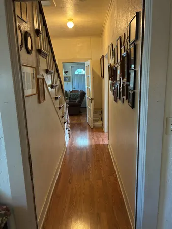 a view of a hallway with wooden floor and stairs