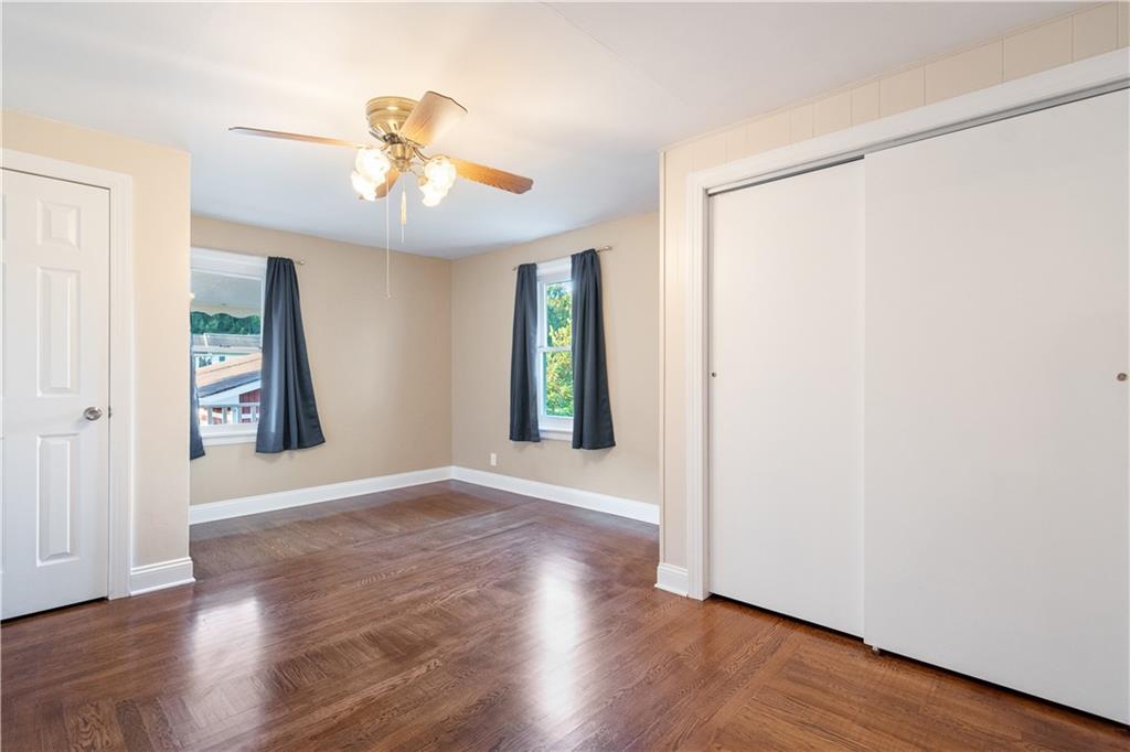 355 Highway 31 Ruffs Dale, PA 15679 - Photo 14 of 25 an empty room with wooden floor chandelier fan and windows