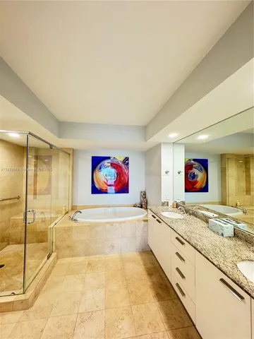 a spacious bathroom with a granite countertop sink mirror and bathtub