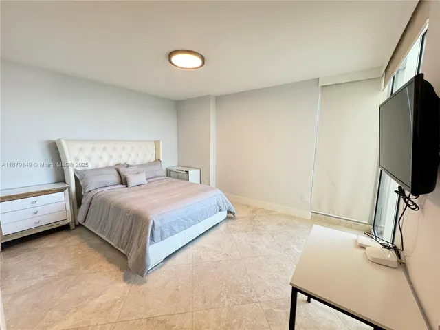 a bedroom with a bed and a flat screen tv