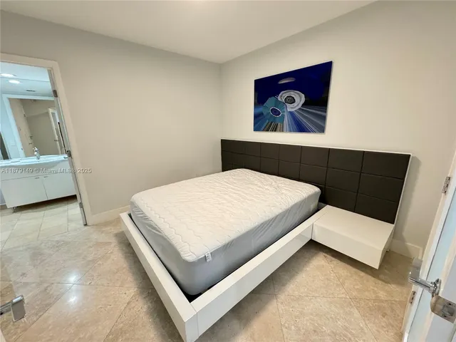 a bedroom with a bed and painting on the wall