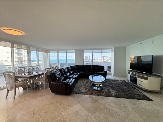 a living room with furniture a flat screen tv and a large window