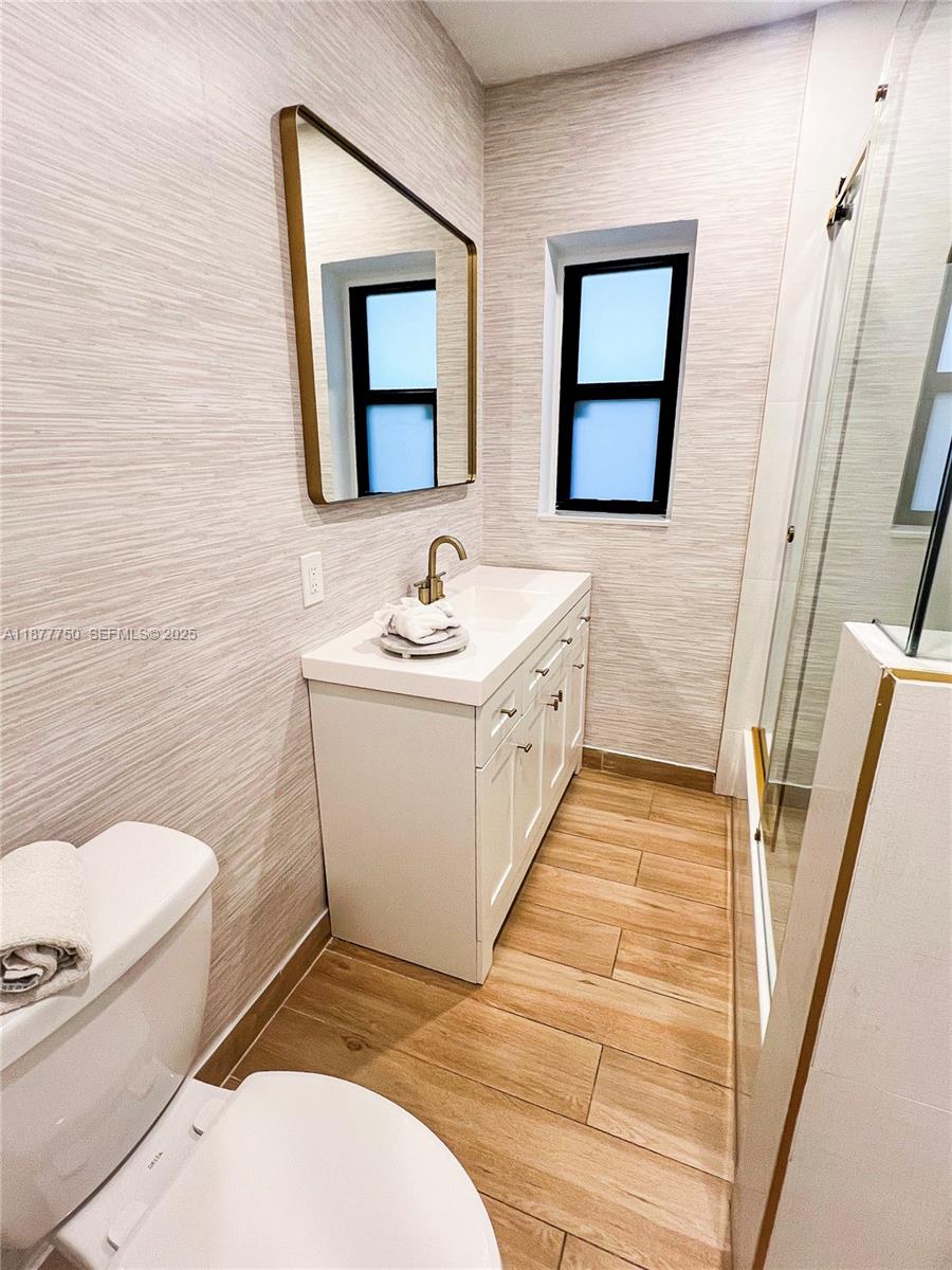 1600 Southwest 17th Avenue Miami, FL 33145 - Photo 11 of 32 a bathroom with a sink a toilet and mirror
