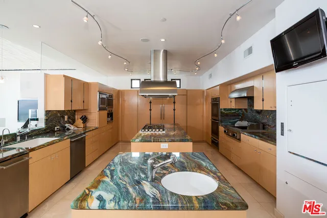 a kitchen with stainless steel appliances kitchen island granite countertop a sink stove and refrigerator