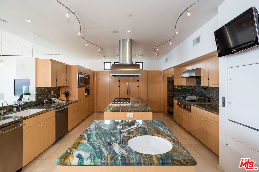 24230 Malibu Road Malibu, CA 90265 - Photo 13 of 27 a kitchen with stainless steel appliances kitchen island granite countertop a sink stove and refrigerator