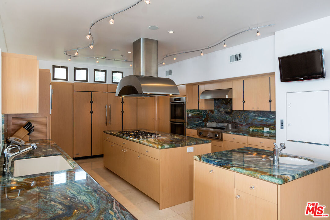 24230 Malibu Road Malibu, CA 90265 - Photo 14 of 27 a kitchen with stainless steel appliances granite countertop a stove oven and a refrigerator
