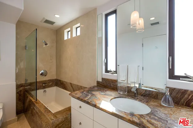 a bathroom with a granite countertop sink and a mirror