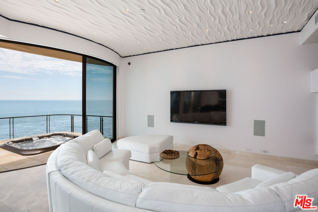 24230 Malibu Road Malibu, CA 90265 - Photo 9 of 27 a living room with furniture and a flat screen tv