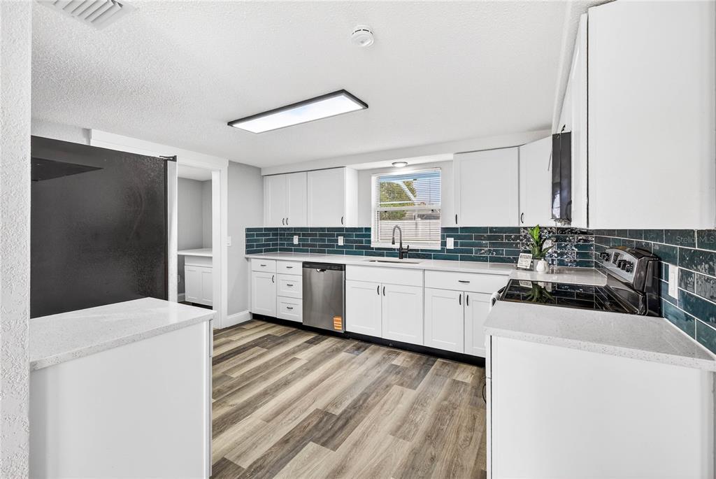11214 Kapok Avenue Port Richey, FL 34668 - Photo 11 of 25 a kitchen with a refrigerator sink and cabinets