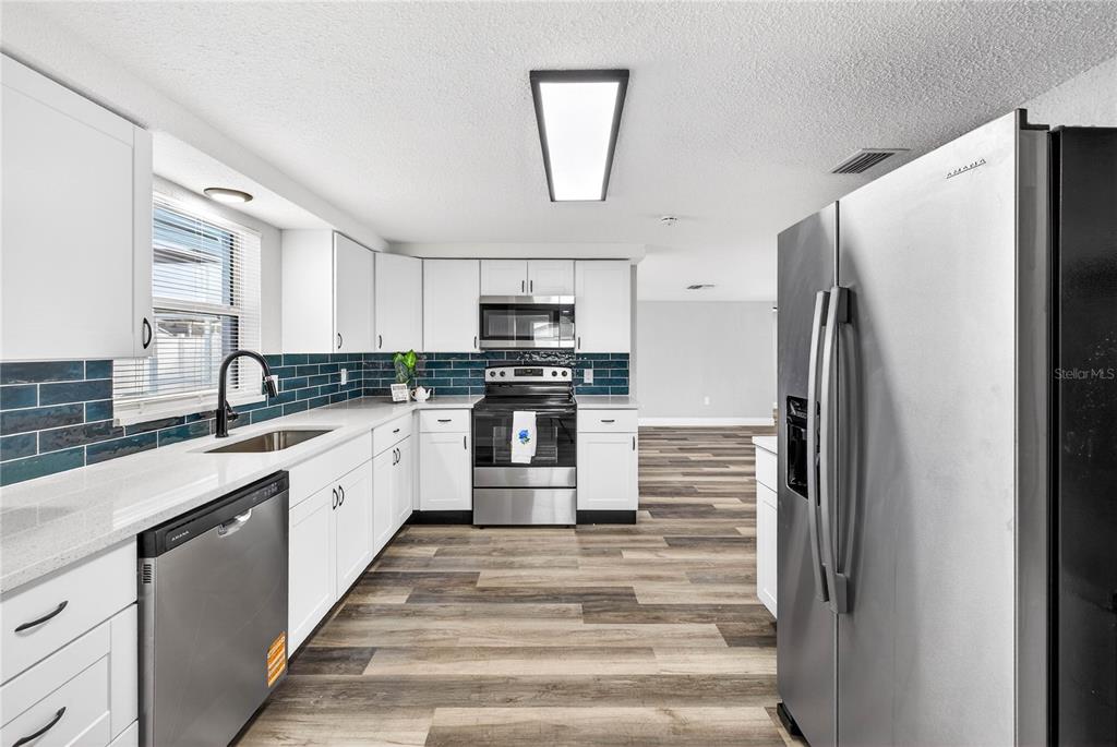 11214 Kapok Avenue Port Richey, FL 34668 - Photo 13 of 25 a kitchen with a refrigerator and a sink
