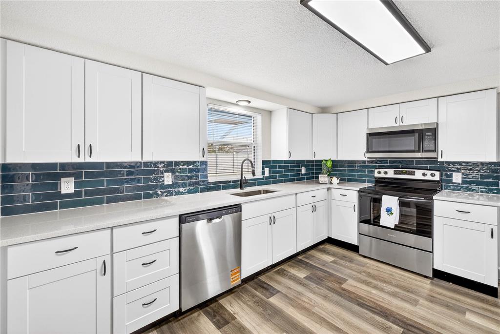 11214 Kapok Avenue Port Richey, FL 34668 - Photo 14 of 25 a kitchen with granite countertop white cabinets and white appliances